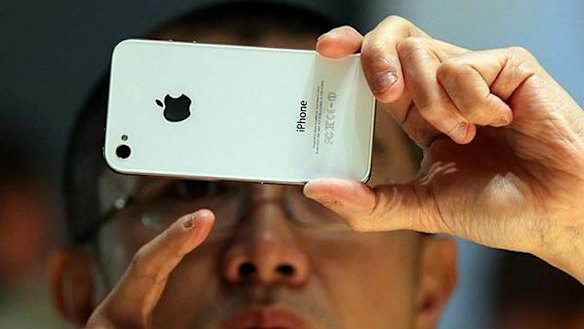 A visitor inspects an Apple iPhone 4 at the Apple Worldwide Developers conference in San Francisco in June.
