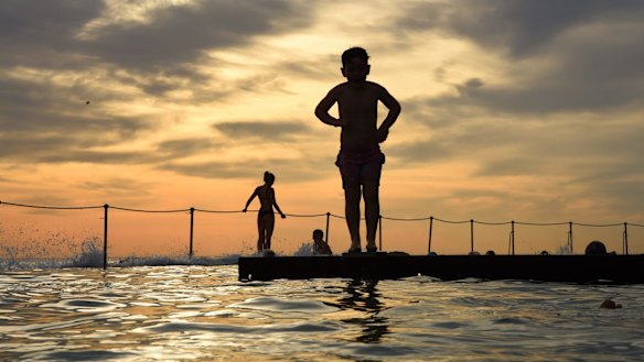 A young boy prepares to dive into the water at Bronte Baths a rock pool at Bronte Beach in the early morning before the temperature soars to 37 degrees. Bronte, Sydney. 