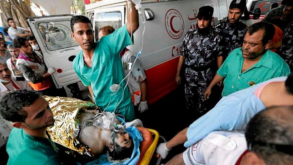 Medics wheel a wounded man into the emergency room at Gaza's Shifa Hospital.