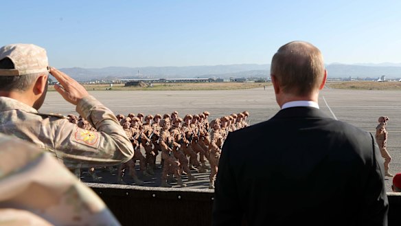 Russian President Vladimir Putin, right, watches the troops marching as he and Syrian President Bashar Assad visit the Hemeimeem air base in Syria in 2017.
