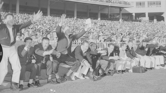 Carlton coach Ken Hands (fourth from left) cheers from the bench as Carlton defeat Geelong in the 1962 replay.
