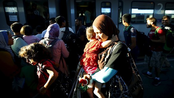 Migrants, many fleeing from warzones, move through Vienna's main railway station on Monday.