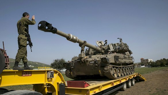 An Israeli soldier directs a mobile artillery unit in the Druze village of Buqata in the Golan Heights on Monday.