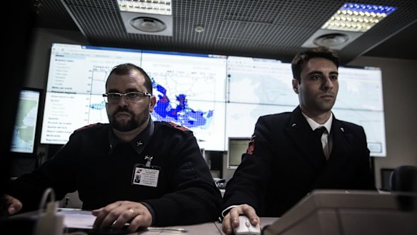 Italian coast guard officers use monitors to track ships navigating the area where the boat believed to be crowded with perhaps as many as 700 migrants capsized in the waters north of Libya.