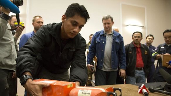 Flight recorders to reveal final moments of MH17: A Malaysian investigator with one of the black box flight recorders at the handover.