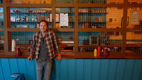 Behind bars: Staff work behind a cage to complete the dive-bar theme.