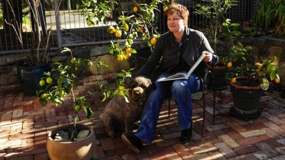 Tracey Ryan, of Ainslie, with her lemon and lime trees, and her dog Marley.