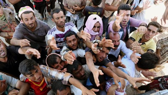 Desperate plight: displaced Iraqis from the Yazidi community gather for humanitarian aid at the Syria-Iraq border last week.