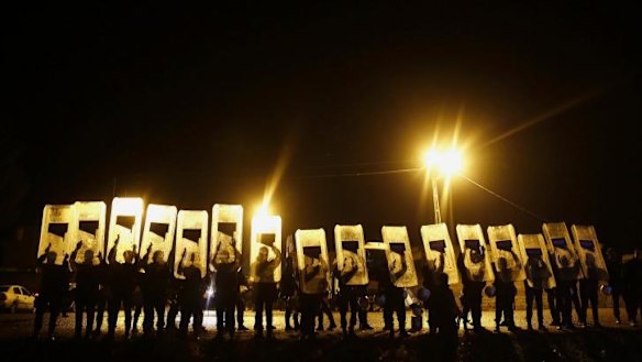 Shielded from view: Turkish riot police lift their shields to block the view of journalists as a convoy of Iraqi Kurdish peshmerga leaves a compound at the border town of Suruc, Sanliurfa province, near Kobane.