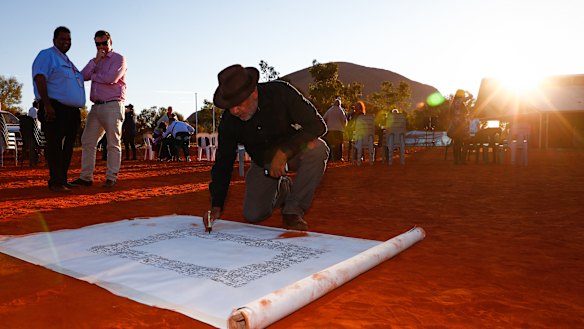 False dawn?: Noel Pearson signs a canvas on which the Uluru Statement from the Heart was later painted in May.