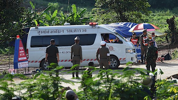 An ambulance carrying the 5th person to be rescued from Tham Luang cave drives past the caves park entrance.
