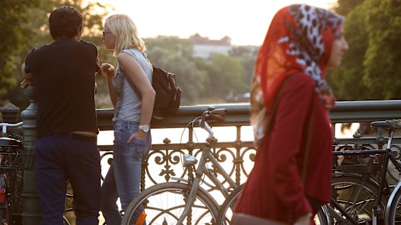 Visitors mingle along the Landwehrkanal in the Kreuzberg district of Berlin.