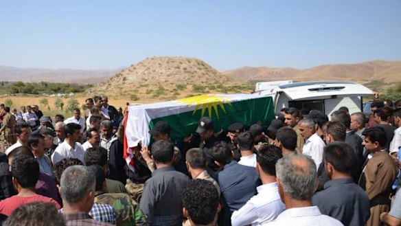 Casualty of war: Mourners carry the coffin of a Kurdish fighter in Iraq's Sulaimaniya province.