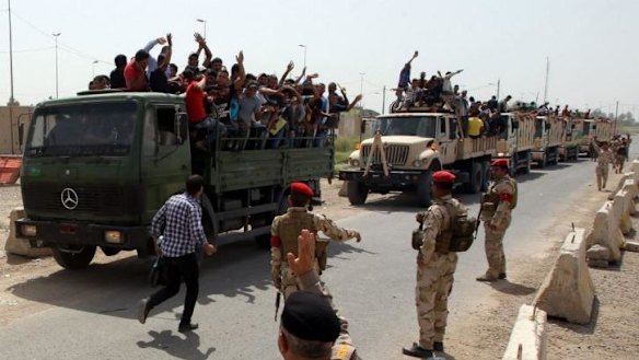 Signing up: Iraqi men who volunteered to join the fight against Sunni militants leave a recruiting centre in Baghdad.