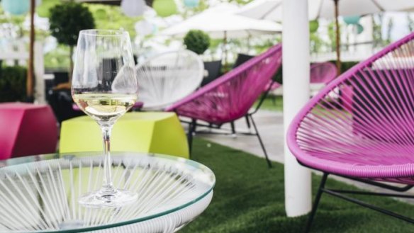 Sip cocktails while lounging on pink string chairs under shady umbrellas.