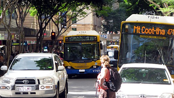 Buses, cars and pedestrians jostle for position on Adelaide Street in Brisbane's CBD.