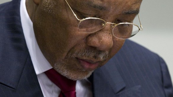 Former Liberian President Charles Taylor takes notes during his trial in 2012 at an international court in The Hague. 