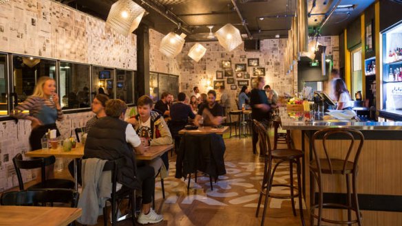 The newspaper-clad main dining room at POW Kitchen.