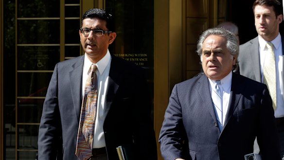 Conservative pundit Dinesh D'Souza, left, accompanied by his lawyer Benjamin Brafman leaves federal court, in New York in 2014.