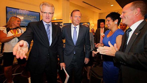Prime Minister Tony Abbott  accompanies LNP candidate for Griffith Bill Glasson (left) to Dr Glasson's  campaign launch, as Premier Campbell Newman and his wife Lisa applaud.