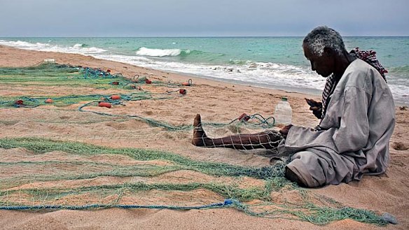 A fisherman tends his nets at Jebel Sifah on the Omani coast.