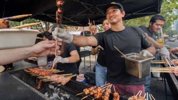 Taste that: Budz leads the cooking team at the Hoy Pinoy Filipino barbecue at the Lunar Markets.