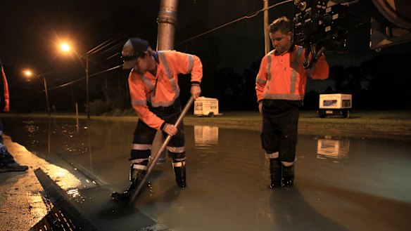 SYDNEY, AUSTRALIA - APRIL 22:  SES volunteers and contractors attempt to alleviate blocked drains on Newbridge Rd Milperra which has flooded and closed the road and access to houses in the area on April 22, 2015 in Sydney, Australia.  (Photo by James Alcock/Fairfax Media)