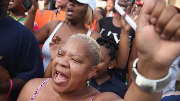 Roxann Evans joins other demonstrators protesting in the street where teenager Michael Brown was killed.