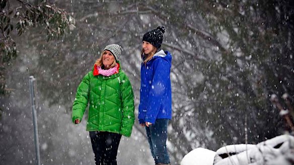 Jaye Fatchen, the owner of Milch Cafe enjoys today's new snow with Amanda Bevilacqua.