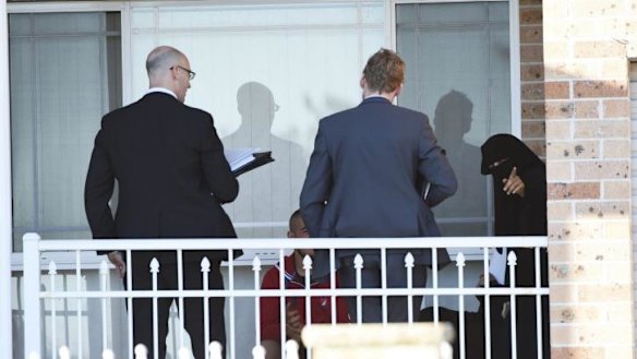 A woman talks to police at a house in Guildford.