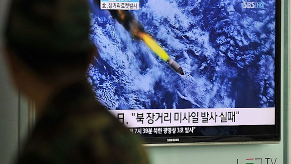 A South Korean man watches a TV screen showing a graphic of North Korea's rocket launch at a train station in Seoul.