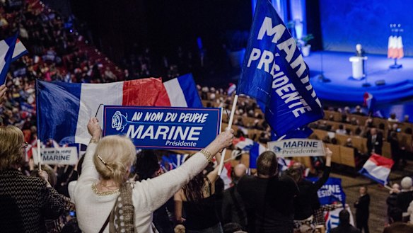 Attendees wave flags and hold signs as Marine Le Pen, leader of the French National Front, speaks in Lyon.