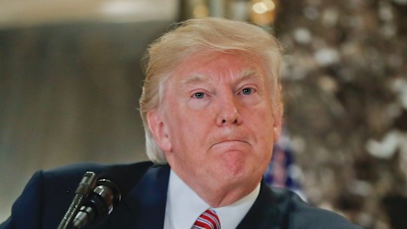 President Donald Trump pauses as he answers questions from members of the media in the lobby of Trump Tower.