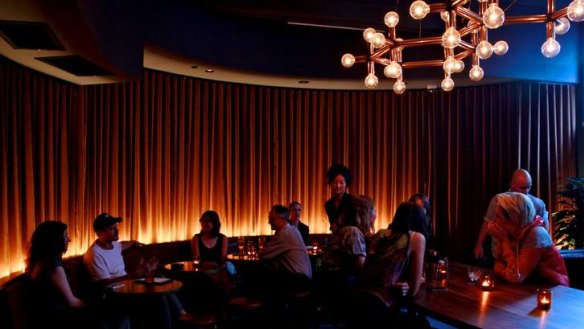 A modernist chandelier hangs elegantly over a communal table.