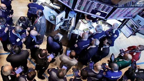 Traders gather at the post that handles Global Payments Inc. on the floor of the New York Stock Exchange, Monday, April 2, 2012, in New York.