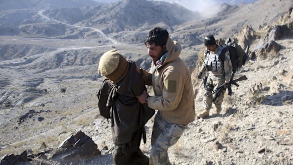 Afghan border policemen escort a  suspected Taliban fighter in Paktika province near the border with Pakistan.
