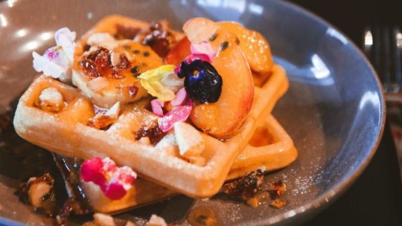 Buttermilk waffles with coconut and lime butter, roasted stonefruit and macadamia.
