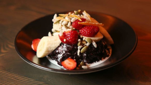 Black sticky rice with strawberries, banana, coconut cream and dried mango.