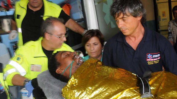 A man is carried off an ambulance at the Palermo Civico hospital, Italy, after being rescued off the Italian island of Lampedusa.