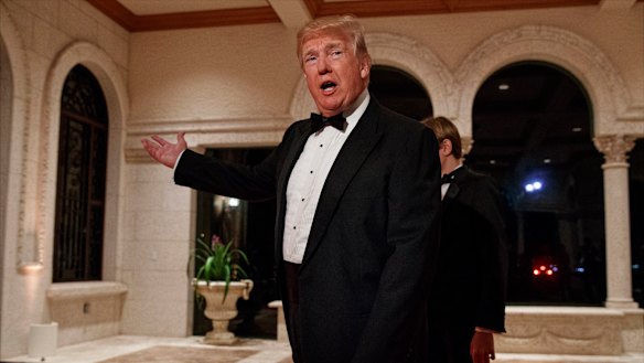 President Donald Trump speaks with reporters as he arrives for a New Year's Eve gala at his Mar-a-Lago resort, in Palm Beach, Florida.