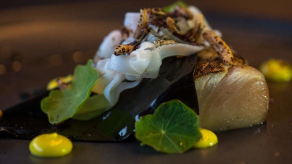 Squid ink-draped kingfish with lemon puree and puffed rice.