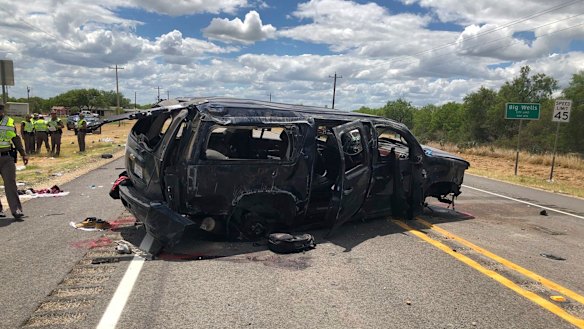 A heavily damaged SUV is seen on Texas Highway 85 in Big Wells, Texas, after crashing while carrying more than a dozen people fleeing from Border Patrol agents.