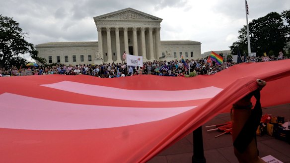 People wave a giant equality flag in celebration outside the Supreme Court in Washington on Friday. 