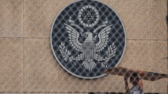 A worker carries cardboard inside the compound of the United States embassy in Havana, Cuba.