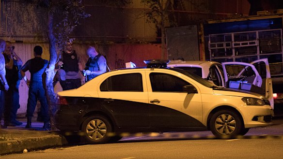 Police officers work next to the car in which Marielle Franco was travelling.