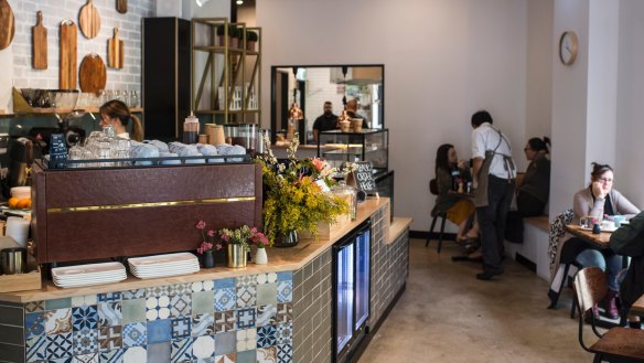The Bells Road Social's counter features a patchwork of tiles and a display of chopping boards.