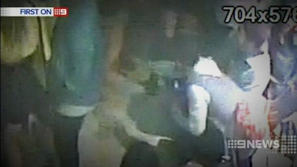 Mitchell Pearce (grey and white attire) is seen reaching across the room.