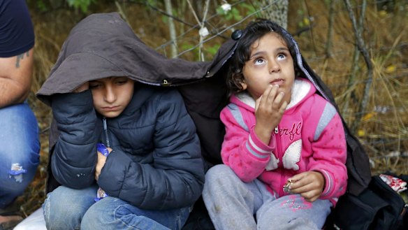 Children of Syrian migrants shelter from the rain near Asotthalom, Hungary.