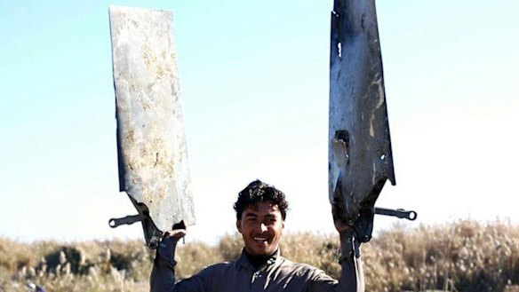 An IS fighter holds pieces of the Jordanian warplane near Raqqa, Syria.