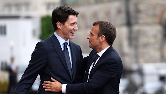 French President Emmanuel Macron, right, and Canadian Prime Minister Justin Trudeau embrace after Macron's arrival on Parliament Hill in Ottawa, Ontario.